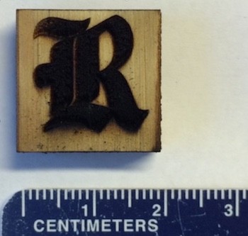 Rice University athletics logo made of laser-induced graphene on block of pine. Rice scientists used industrial laser to heat wood and turned its surface into highly conductive graphene that could be used for biodegradable electronics