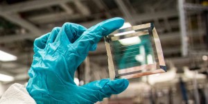 Xinjing Huang, a doctoral student in Forrests lab, holds a solar cell module with 40 transparency, based on the formula with an estimated 30-year lifetime Photo Robert CoeliusMichigan Engineering