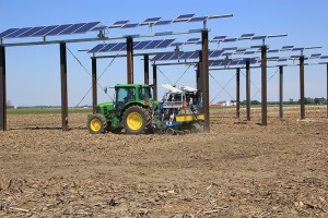 A tractor plants corn seed in early June around solar photovoltaic panels in a field north of the Agronomy Center for Research and Education The panels are part of the Sustainable Food, Energy and Water Systems SFEWS research project intended to examine h A tractor plants corn seed in early June around solar photovoltaic panels in a field north of the Agronomy Center for Research and Education The panels are part of the Sustainable Food, Energy and Water Systems SFEWS research project intended to examine h