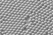 A scanning electron microscope image shows the microscale concave interface structure that was studied The material consists of microspheres partially embedded in sticky tape, forming microscale concave interfaces Credit Jacob Rada