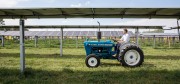 Byron Kominek, owner of Jacks Solar Garden, riding his familys tractor through their solar power system Photo courtesy of Werner Slocum, National Renewable Energy Laboratory