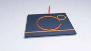 The two rings in the image are microresonators The bigger ring is the one where the microcomb is generated The microcomb is formed by a pulse of lighthere illustrated with a red spike and also known as a soliton - that recirculates in the cavity forever T